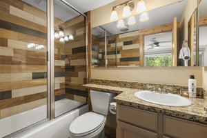 The en suite bathroom has a bathtub and shower combination.