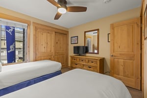 The second bedroom has two twin beds and flat screen TV.