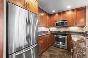 The wellequipped kitchen has stainless steel appliances and rich wood cabinetry.