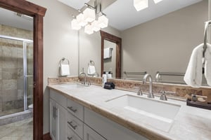 The en suite bathroom has a two sink vanity and separate water closet.