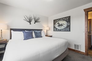 The second bedroom offers a kingsize bed and wood furniture.