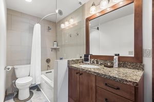 The en suite bathroom has a double sink vanity and bathtub and shower combination.
