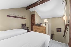 The loft offers two twin beds and wooden dresser.