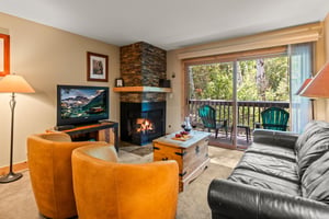 A cozy living room with gas burning fireplace and flat screen TV.