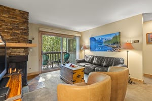 The living room has a comfortable leather couch and two club chairs.