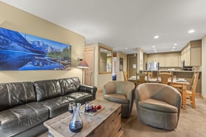 The living room has a comfortable leather couch and two club chairs.