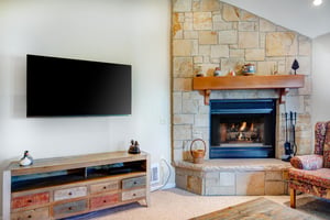 The living room has a flat screen TV and gas burning fireplace.