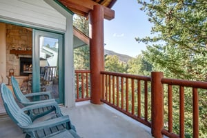 The private deck has views of the mountain and beautiful trees.