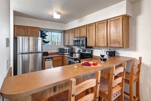 The wellequipped kitchen offers a breakfast bar and stainless steel appliances.