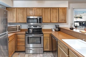 The wellequipped kitchen offers a breakfast bar and stainless steel appliances.