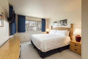 The main bedroom with a king size bed overlooking aspen groves