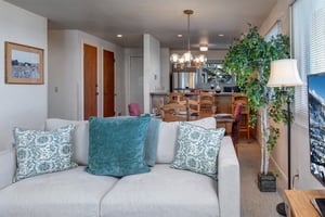 A comfortable loveseat with blue throw pillows.