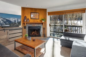 The living room has comfortable couches, gas burning fireplace and views of the aspen grove.