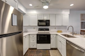 The wellequipped kitchen has white cabinetry.