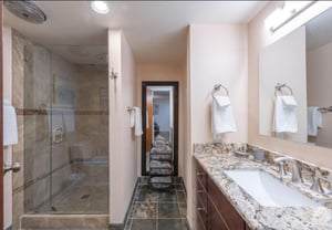 Upgraded guest bathroom features a tiled walkin shower