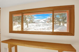 View from the locker room of Park City Mountain Resort covered in snow with evergreen trees.