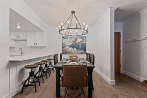The dining table has 6 chairs, beautiful chandelier and moose artwork.