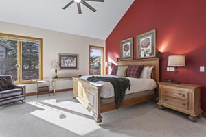 The spacious main suite with a kingsize bed and red accent wall.