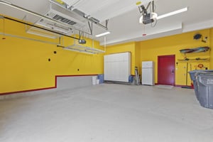 The garage painted yellow with a red door and trim and new floor finish.