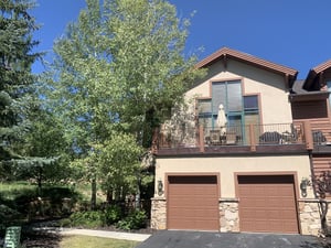 The exterior of the townhome with a two car garage and outside patio on the second level.