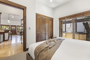 Town Lift Chalets second bedroom with sliding glass doors and lovely wooden blinds that are pulled up to allow light in.