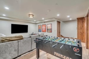 Foosball table  sits behind the sectional in the game room