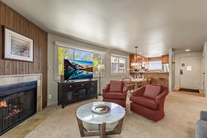 The living room offers comfortable furniture, flat screen TV and large windows with views of the aspen trees.
