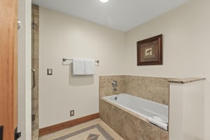 The en suite bathroom has a deep soaker bathtub.
