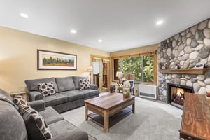 The living room offers grey suede couches and a wooden coffee table.