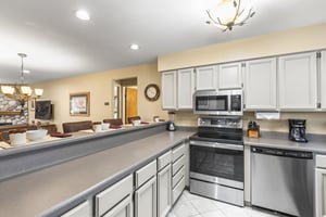 The wellequipped kitchen with grey cabinets and stainless steel appliances.
