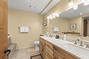 The en suite bathroom has a double sink vanity