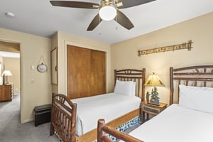 The second bedroom has two twin size beds with log frames.
