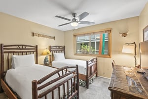 The second bedroom has two twin size beds with log frames.