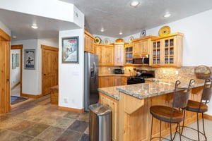The wellequipped kitchen offers solid wood cabinets, granite counters and spacious floor plan.
