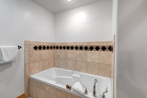 The en suite bathroom offers a deep soaker bathtub.
