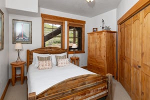 The second bedroom has a queen size bed and wood armoire.