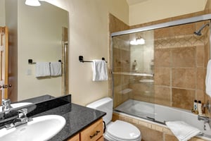 The shared bathroom with a bathtub and shower combination.