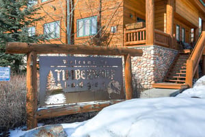 Timber Wolf Lodge sign with snow on the ground.