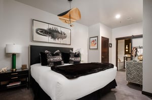 The main room with king bed and black and white furnishings with touches of gold.