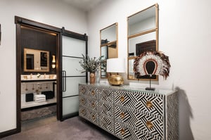 The main room with black and white dresser and stylish decor with gold accents.