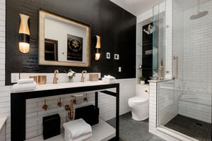 The en suite bathroom done in black, white and gold and two sink vanity.