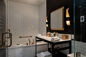 The en suite bathroom done in black, white and gold and deep soaker tub.