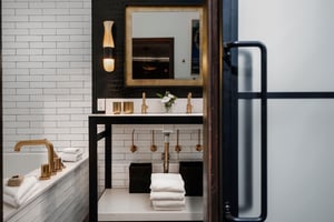 The en suite bathroom done in black, white and gold and two sink vanity.
