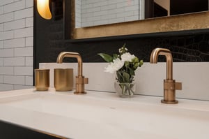 Gold faucets and flowers on the two sink vanity.