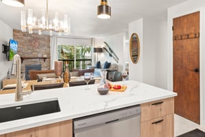 The breakfast bar has beautiful lighting and white countertops.