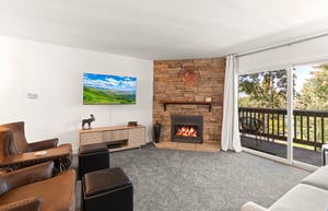 The living room has comfortable furnishings, gas burning fireplace, and flat screen TV.