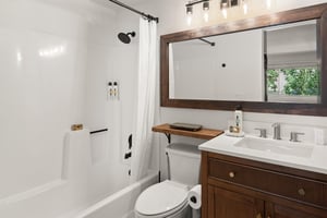 The en suite bathroom has a bathtub and shower combination and single sink vanity.