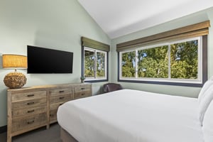 The main suite has a king size bed, dresser, and flat screen TV.