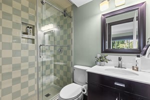 The en suite bathroom has a walkin shower and single sink vanity.