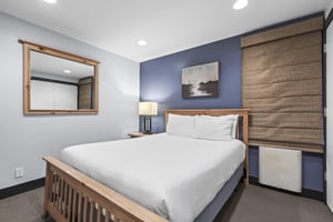 The second bedroom has a queen size bed and blue accent wall.